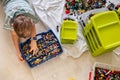 Khabarovsk, Russia, February 18, 2022. Teenager male sorting heap of small Lego pieces into boxes
