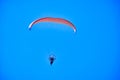 Khabarovsk, Russia - May 02, 2022: A paraglider with a red parachute flies against the blue sky. Royalty Free Stock Photo