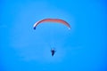 Khabarovsk, Russia - May 02, 2022: A paraglider with a red parachute flies against the blue sky. Royalty Free Stock Photo