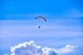 Khabarovsk, Russia - May 02, 2022: A paraglider with a red parachute flies against the blue sky. Royalty Free Stock Photo