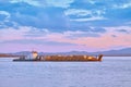 Khabarovsk, Russia - Sep 29, 2021: Sunset on the embankment of the Amur river in Khabarovsk. A barge with timber floats