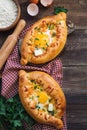 Khachapuri Ajarian on rustic wooden background