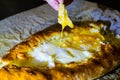 Khachapuri in Ajarian. Woman is eating adjarian khachapuri with hands, crushing egg yolk. Royalty Free Stock Photo