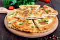 Khachapuri with cottage cheese and greens on a board