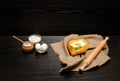 Khachapuri with eggs on sackcloth, salt, flour, eggs and parsley on the black table, side view Royalty Free Stock Photo