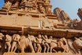 Khajuraho temple reliefs, India. Artworks on walls of 10th century temple with animals, wariors, horseriders Royalty Free Stock Photo