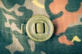 Khaki button on the fabric with a camouflage pattern. Background