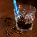 Khalua drink with ice in glass with blue straw and coffee beans on wooden table Royalty Free Stock Photo