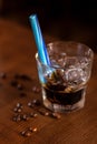 Khalua drink with ice in glass with blue straw and coffee beans on wooden table Royalty Free Stock Photo