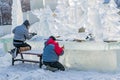 KHANTY-MANSIYSK, RUSSIA - DECEMBER 2, 2017:Employee in the town square built out of pieces of ice, ice sculpture, winter landscape