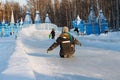 KHANTY-MANSIYSK, RUSSIA-January 23, 2019:Children ride from the ice slide in winter on the street square. Theme outdoor winter ent