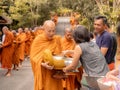 Khao Yai, Thailand - April 23, 2019: Buddhist Monks Line up in Row Waiting for Buddhism People to Give Alms Bowl in Makut Khiriwan