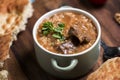 Kharcho soup with lamb meat served in a clay bowl with lavash flatbread