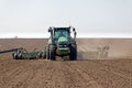 Tractor with trailed seeder on the field