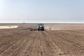 Tractor with trailed seeder on the field