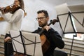 A young musician plays the cello, next to the notes