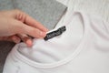 KHARKIV, UKRAINE - 11 AUGUST 2017: Boohoo black tag on white T-shirt in a female hand. Close-up