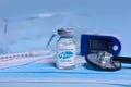 Kharkiv. Ukraine. February 1, 2021. Coronavirus vaccine vial with Pfizer logo , syringe, mask, pulse oximeter, thermometer,gloves