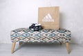 KHARKIV, UKRAINE - 10 February, 2021: Illustrative editorial of Adidas branded paper package on a cocktail ottoman