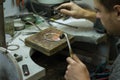 KHARKIV, UKRAINE - January 31, 2019: The master jeweler holds the working tool in his hands and makes jewelery at his workplace
