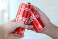 Couple hands raises red Coca cola cans in garage interior