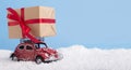 Creative Christmas background with small retro car Volkswagen Beetle and big gift