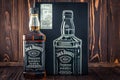 Kharkiv, Ukraine, March 22, 2020: A full bottle of American whiskey Jack Daniel`s and black metal box on dark wood planks