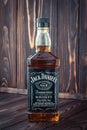 Kharkiv, Ukraine, March 22, 2020: A full bottle of American whiskey Jack Daniel`s on dark wooden board background. Strong drink.