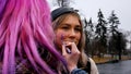 A girl with pink hair draws a gender sign on another girl's cheek. Fighting for women's rights