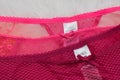 KHARKIV, UKRAINE - September 19, 2019: Label M&S on two lacy pink panties on white fur. Close up. Fashionable concept of lingerie Royalty Free Stock Photo