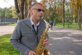 Kharkiv, Ukraine, September, 2019 Man plays on saxophone in the park. Street musician with sax performs music for charity. Public Royalty Free Stock Photo