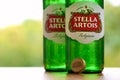 Bottles of Stella Artois beer on blurred green trees background Royalty Free Stock Photo