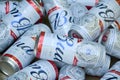 Many Cans of Budweiser Lager Alcohol Beer lies on camo surface. Budweiser is Brand from Anheuser-Busch Inbev most popular in