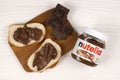 KHARKOV, UKRAINE - DECEMBER 27, 2020: Nutella glass can and spread on freshly baked bread. Nutella is manufactured by Italian