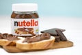 KHARKOV UKRAINE - DECEMBER 27 2020: Nutella glass can and spread on freshly baked bread. Nutella is manufactured by Italian