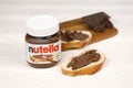 KHARKOV UKRAINE - DECEMBER 27 2020: Nutella glass can and spread on freshly baked bread. Nutella is manufactured by Italian