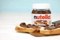 KHARKOV UKRAINE - DECEMBER 27 2020: Nutella glass can and spread on freshly baked bread. Nutella is manufactured by Italian