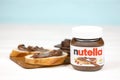 KHARKOV, UKRAINE - DECEMBER 27, 2020: Nutella glass can and spread on freshly baked bread. Nutella is manufactured by Italian