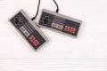 KHARKOV  UKRAINE - DECEMBER 27  2020: Two old gamepads for 8-bit video game consoles nintendo entertainment system and nes mini on Royalty Free Stock Photo