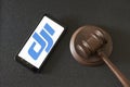 KHARKOV, UKRAINE - JUNE 25, 2020: Dji logo on the phone display and judges gavel. Black background. Top view Royalty Free Stock Photo