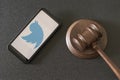 KHARKOV, UKRAINE - JUNE 25, 2020: Smartphone with Twitter apps on screen and wooden judge gavel