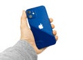 Kharkov, Ukraine - March 12, 2021: Backside of Apple iPhone 12 Paciffic Blue color, man holds popular smartphone in hand