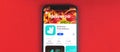 Kharkov, Ukraine - May 28, 2021: Banner with Deliveroo food delivery app on the screen of Apple iPhone, red background