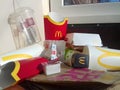 Used paper wrappings and disposable packs with McDonalds design and logo in pile on table. McDonalds recycle trash after usage
