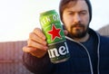 KHARKOV, UKRAINE - NOVEMBER 26, 2019 Young bearded man holds a bottle of Heineken Dutch beer