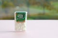 Many Tic Tac Candy packages on green wood background. Tic tac is popular due its minty fresh taste and easy to carry. Hard mints