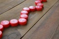 Many red caps with coca cola logo on wooden background Royalty Free Stock Photo