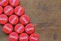 Many red caps with coca cola logo on wooden background Royalty Free Stock Photo