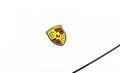 Porsche brand logo on a white car background, emblem, symbol close-up