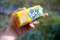 Tuc snack pack in male hand on a green trees background